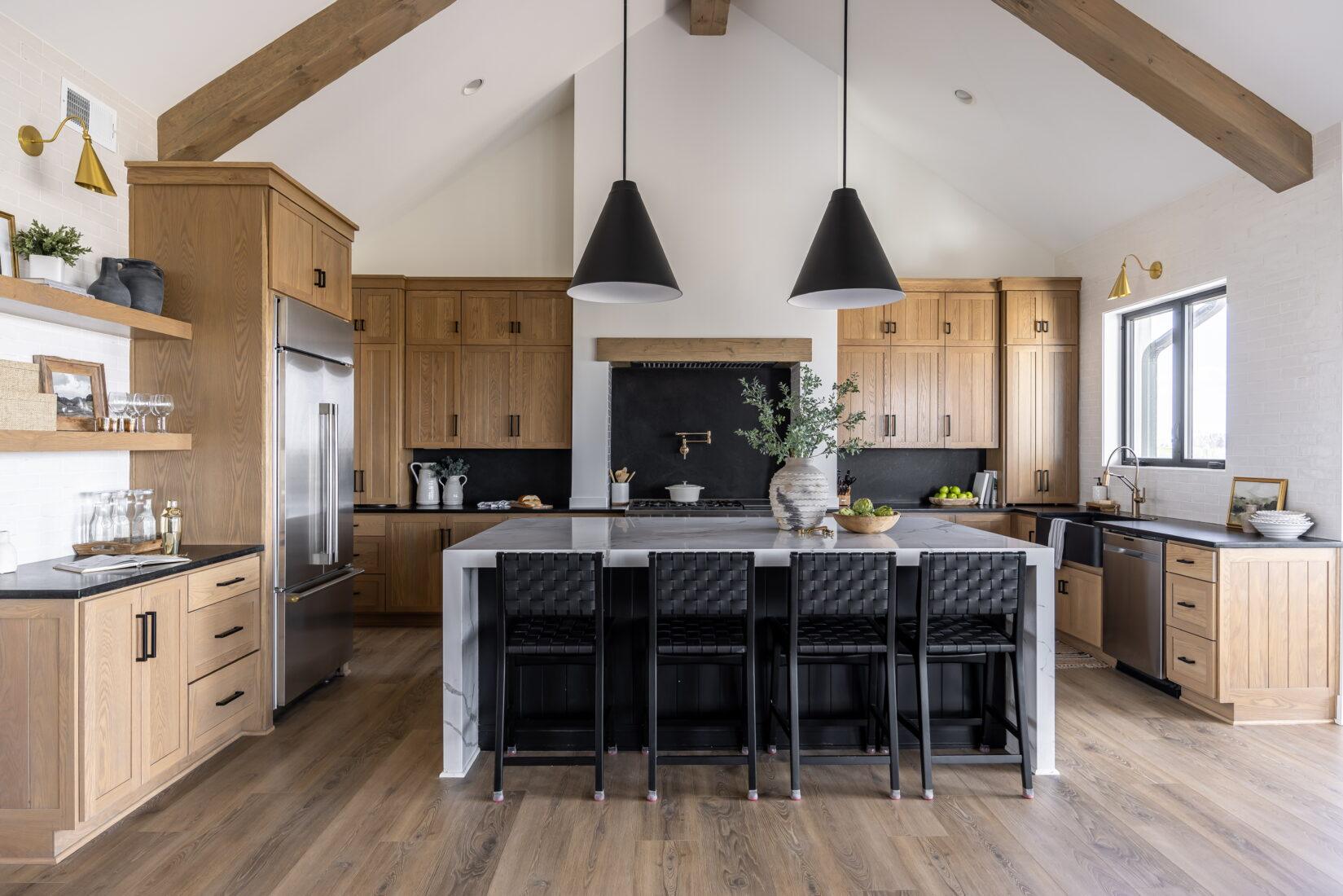 Whole home renovation in Omaha featuring a custom kitchen with vaulted ceilings, exposed wood beams, large island, and open-concept design