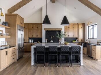 Whole home renovation in Omaha featuring a custom kitchen with vaulted ceilings, exposed wood beams, large island, and open-concept design